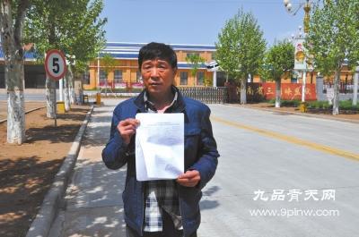 刘建国拿着检测报告在河南省三门峡监狱门口