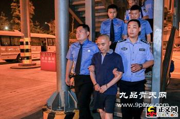 陈士东在成都市检察院检察官和法警的押解下走出舱门。